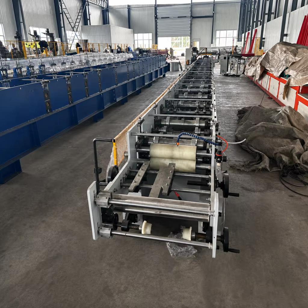 Full roll forming production line view looking down from the infeed guide table in factory workshop